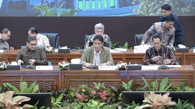 Japanese and Indonesian energy executives reviewing Arafura Sea offshore deepwater LNG drilling plans at a conference table